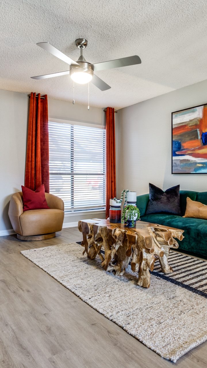 a living room with a green couch and a fan at The  Reid Apartments