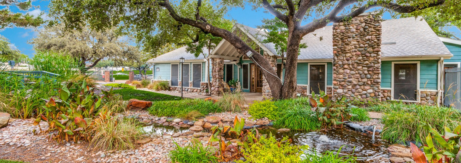 a home with a large garden and trees at The  Reid Apartments